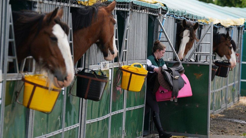 A rider takes a saddle from a stall at the Royal Highland Centre