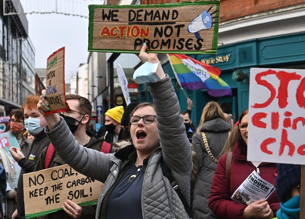 Protesters chant and hold placards at the climate change rally in Belfast