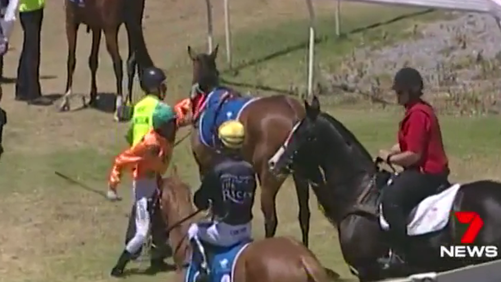 A video still of jockey Dylan Caboche about to hit a horse prior to a race