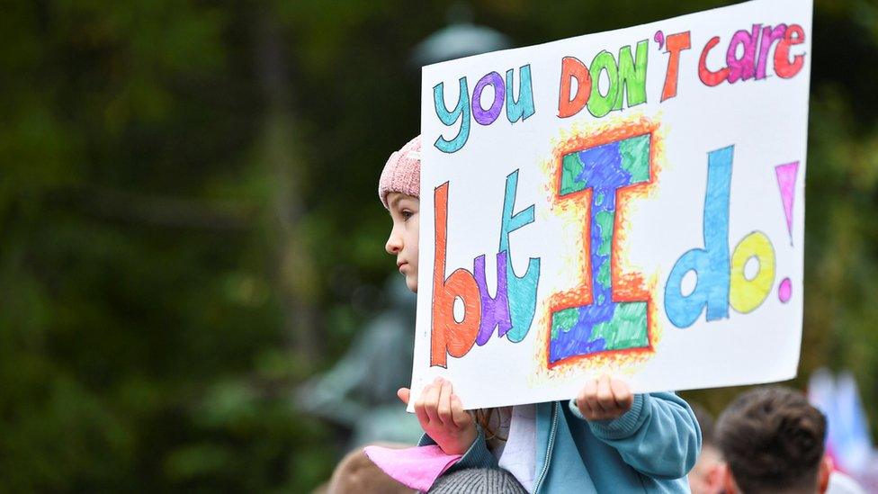 A child holds up a sign at the climate march in Glasgow.