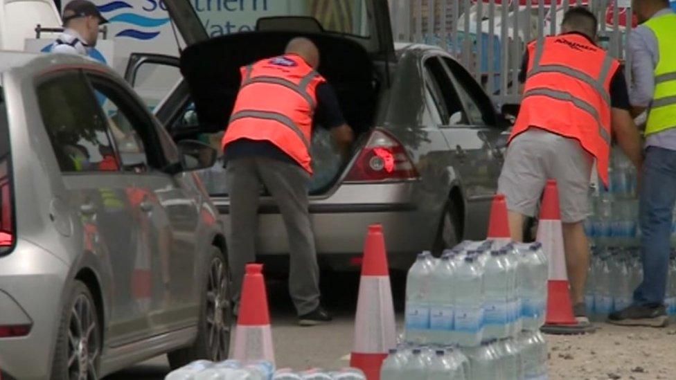 People putting water in cars