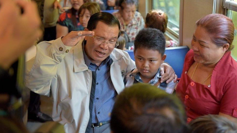 Cambodian Prime minister Hun Sen (L) talks with passengers on a train at the Phnom Penh train station on April 30, 2016, as the railway service resumes after years of suspension.