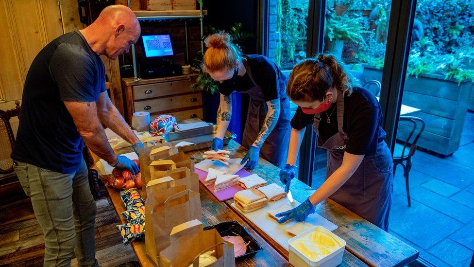 Owner Keith Perryman (left) and staff Helen Manning and Owen Kirkwood prepare sandwiches in The Watering Can, in Greenbank Park, Liverpool, who are providing free school meals for children over the half term holidays.