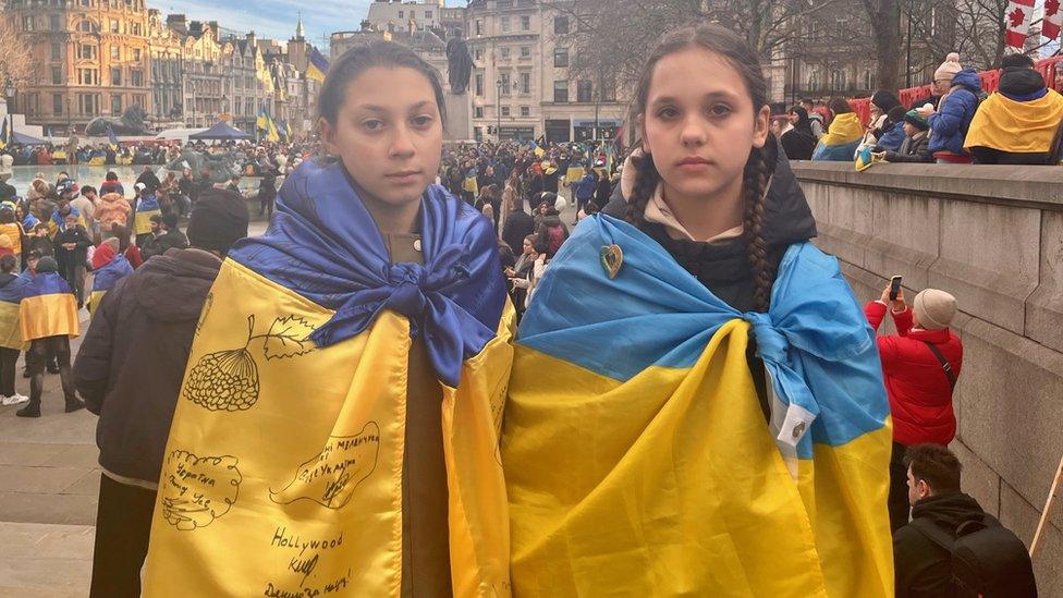 Two young girls draped in Ukrainian flags in London