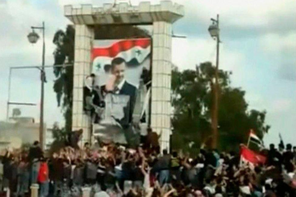 Protesters tear down a portrait of Bashar al-Assad in Deraa (March 2011)