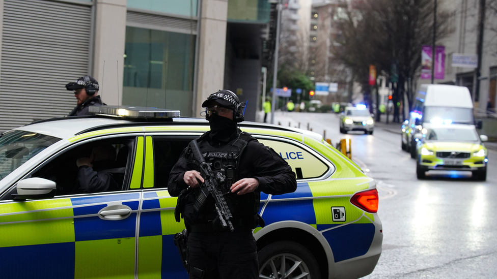 Armed police escort a van into Manchester Crown Court