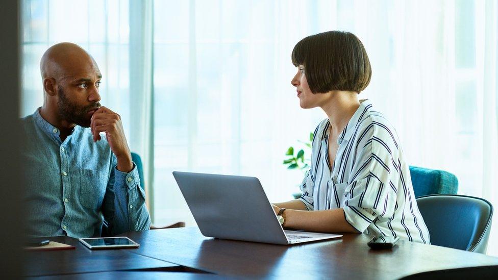 An employee talks to a female boss