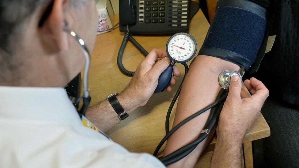 GP checking a patient's blood pressure