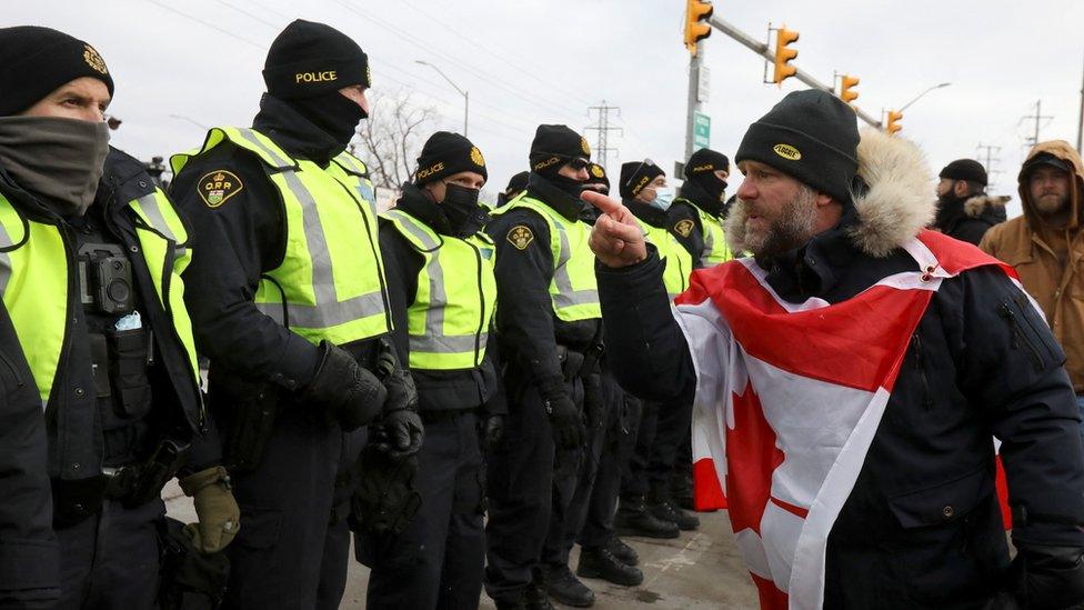 A protester confronts police