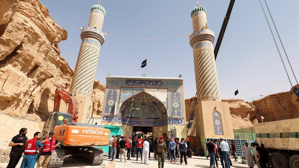 Rescuers search for survivors in the rubble of the Qattarat al-Imam Ali shrine on the outskirts of the holy city of Karbala (21 August 2022)