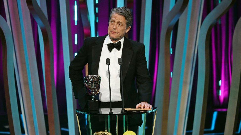 Hugh grant onstage at Baftas