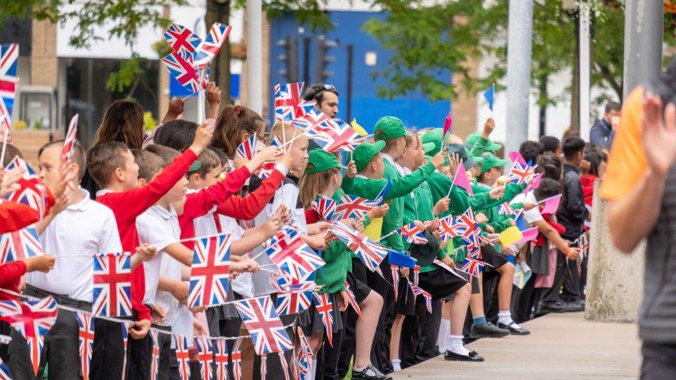 Schoolchildren lining the street wave Union flags as the relay reaches Middlesbrough