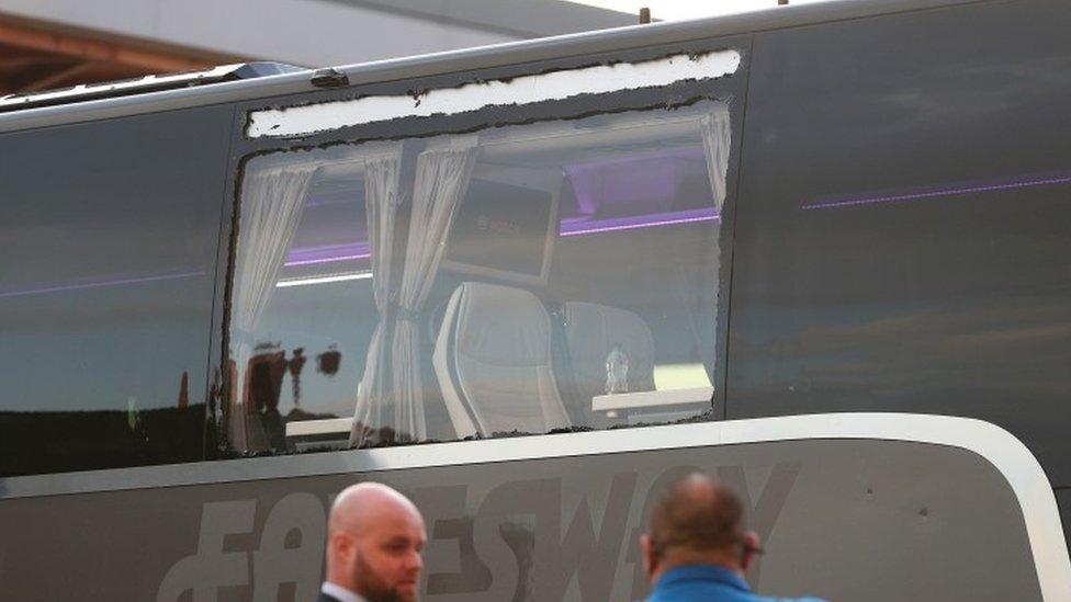 Real Madrid team bus showing damage to a window