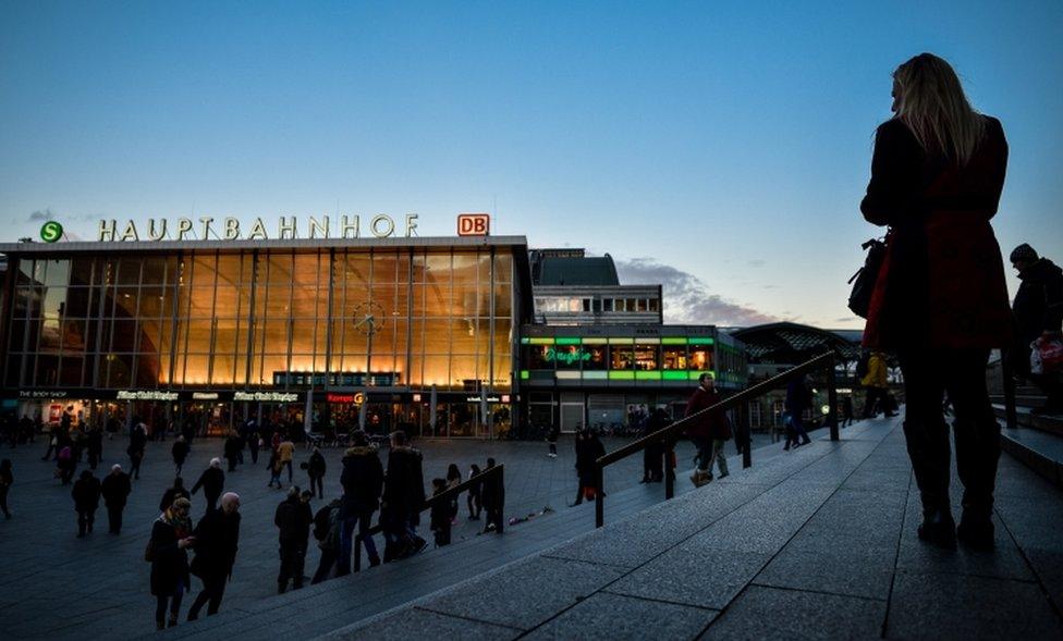 Women, seen in silhouette, stand near Hauptbahnhof main railway station, in Cologne, Germany