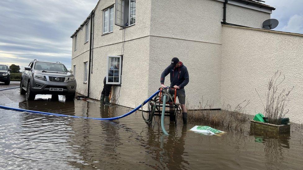 Rick draining flood water away from his home