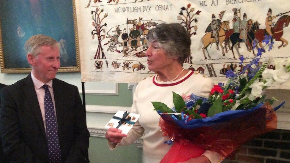 Vice Adm Sir Ian Corder presenting Kate Russell with her British Empire Medal in Alderney's Islands Hall