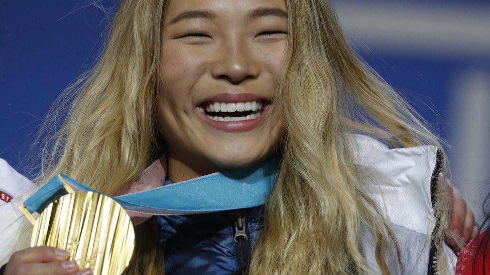 Chloe Kim holding her Olympic gold medal