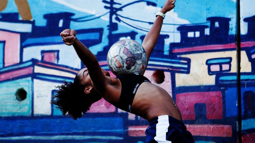 Thamires cushions a ball on her chest, arms outstretched for balance and back tilted far backwards