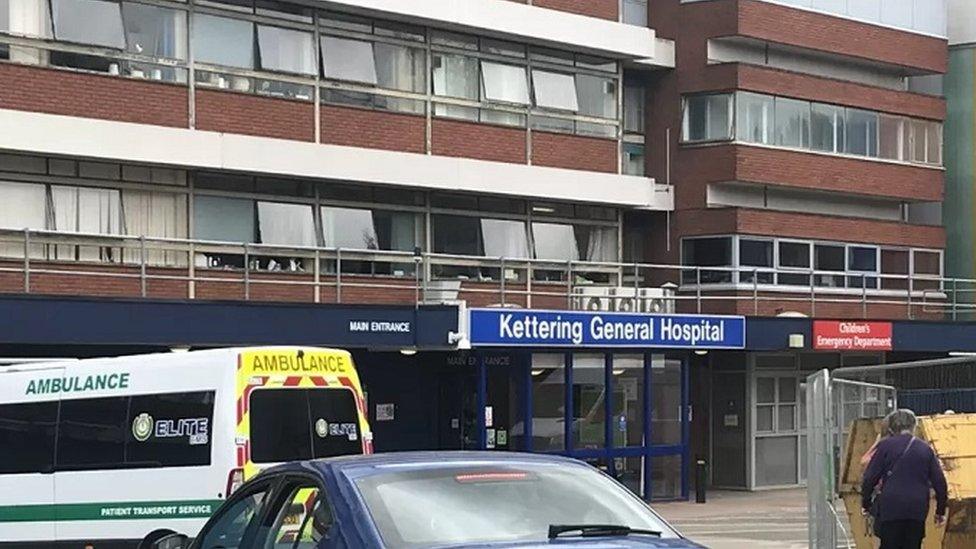 Hospital front entrance with ambulance parked outside