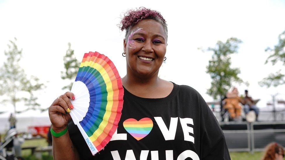 An attendee waves a rainbow fan at the event