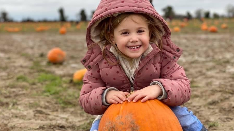 Lyla Blue Glennen smiling with a pumpkin