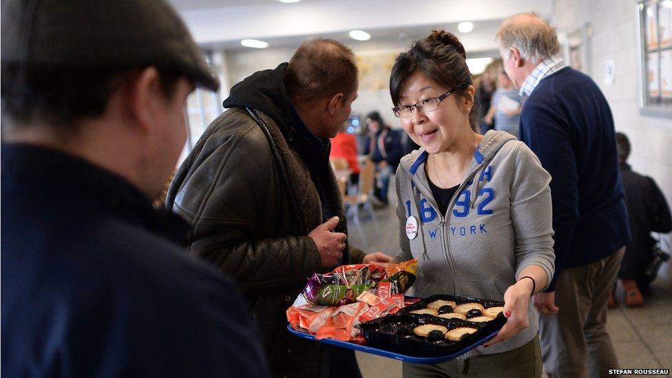 Volunteer offers mince pies to homeless visitor