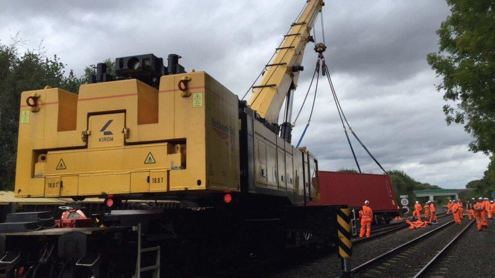 Workers retrieving one of the derailed wagons