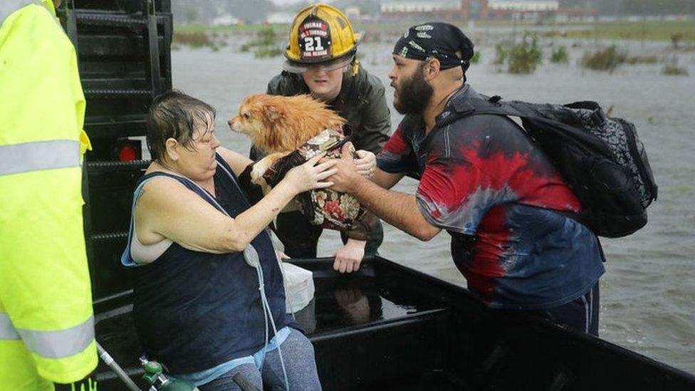 A woman and her dog being rescued