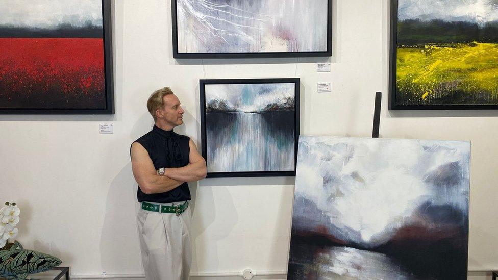 Ian with his paintings in the gallery