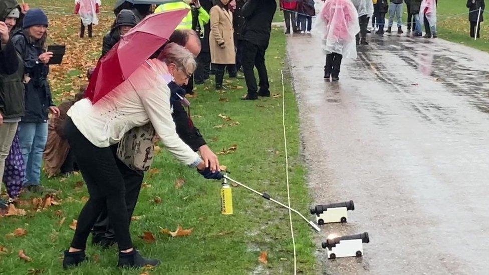 woman lights fuse on cannon