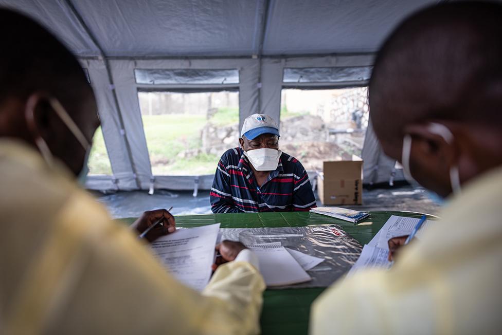 Nicolas gives his details to nurses in the vaccine tent