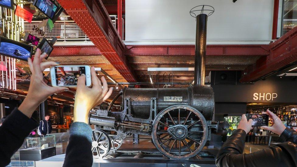 People take image of rocket engine at the museum