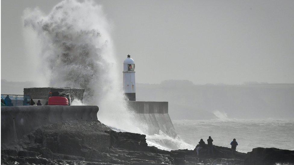 A wave slaps against the harbour wall at Porthcawl, Wales