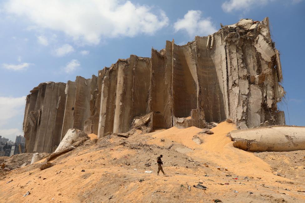 A member of the Lebanese army walks past a wrecked grain silo at the site of a deadly blast in Beirut's port area, on 7 August 2020