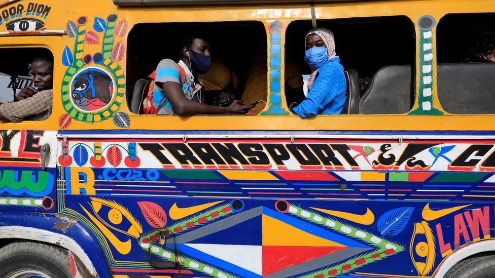 Passengers wait on a bus called "Car Rapide" to be full at a bus station in Dakar, Senegal - 24 June 2020