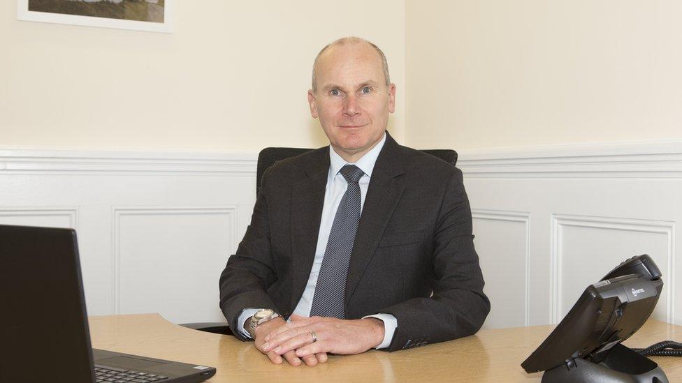 Photo of Aidan Baglow at a desk