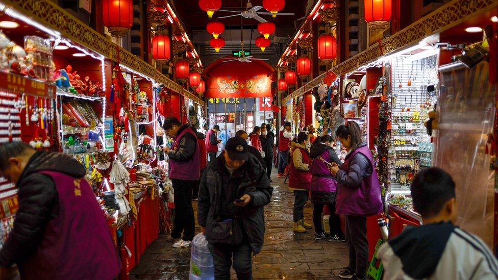 People walk inside a shopping district in Beijing, China, 09 December 2023.