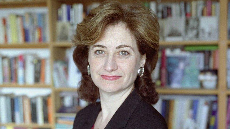 Image of Nicolette Jones looking at the camera sitting in front of a bookcase