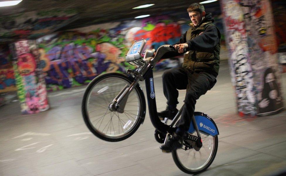 Teenager doing stunts on bike on South Bank