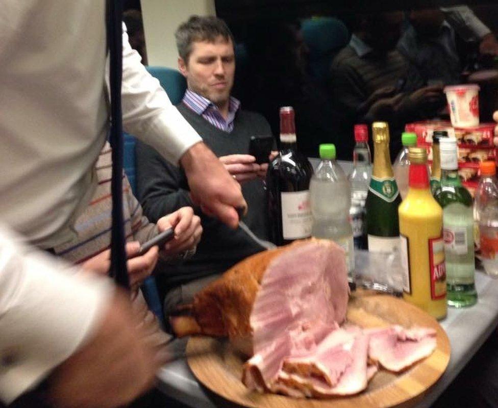 Commuters carving a ham on the train