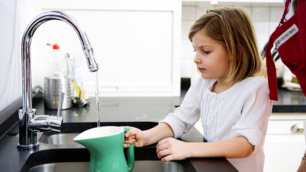 girl-filling-jug-with-water.