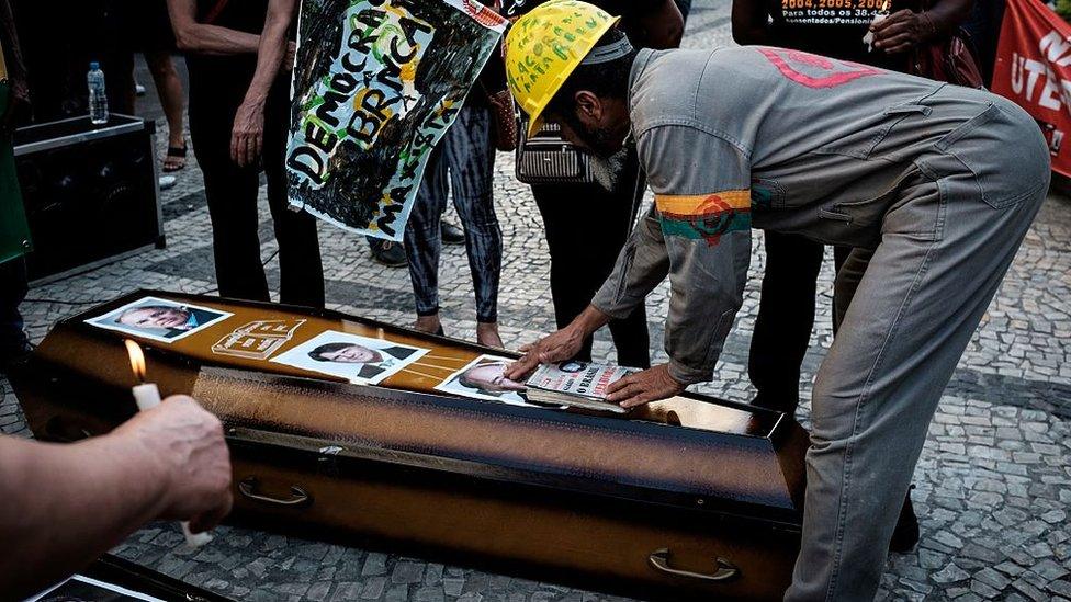 Workers of Brazilian oil company Petrobras takes part in a protest against the privatization of any section of Petrobras with coffins displaying pictures of directors and CEO Pedro Parente