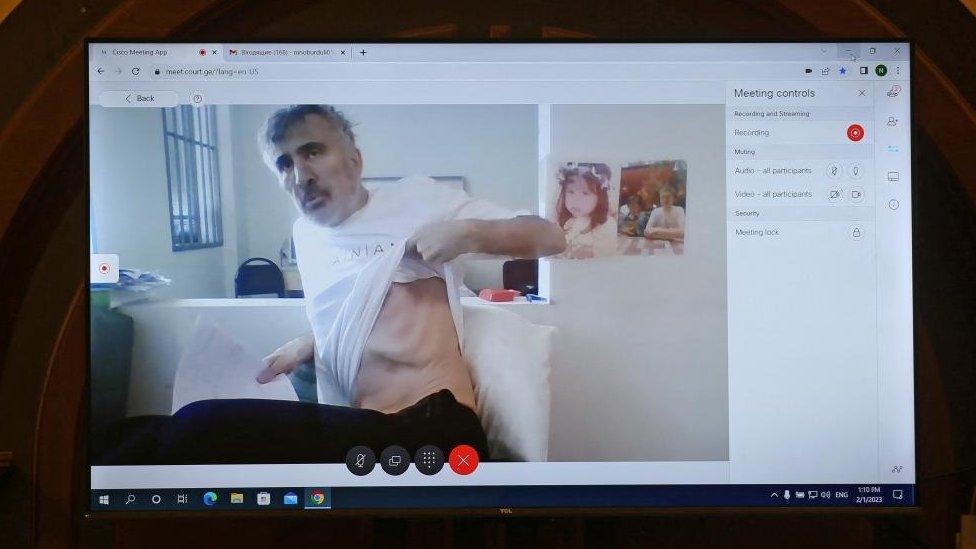 Mikheil Saakashvili appears via video link and shows his ribcage