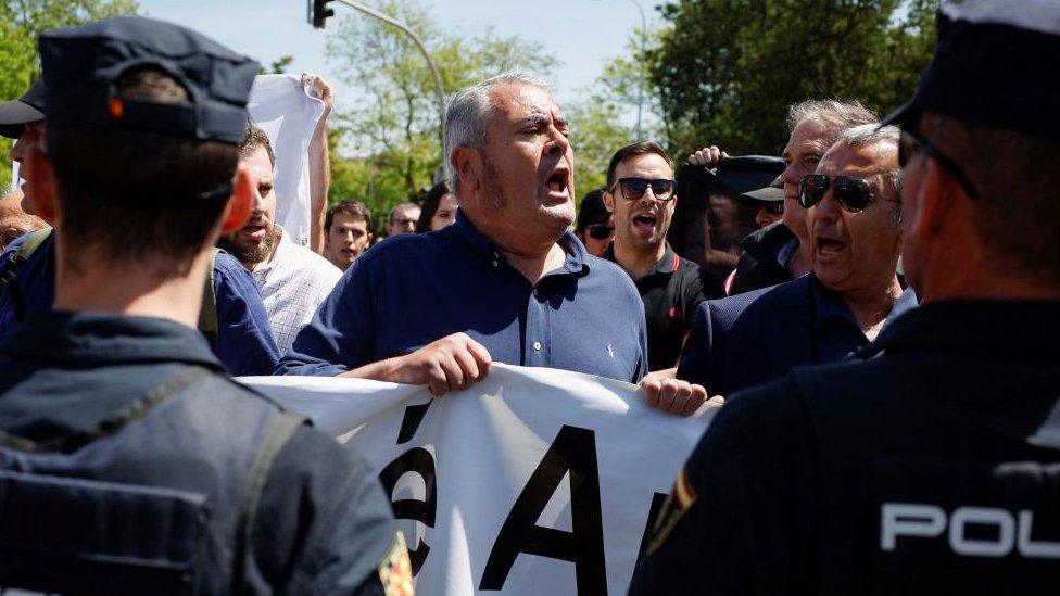 A man among a crowd of Jose Antonio Primo de Rivera supporters confronts police officers