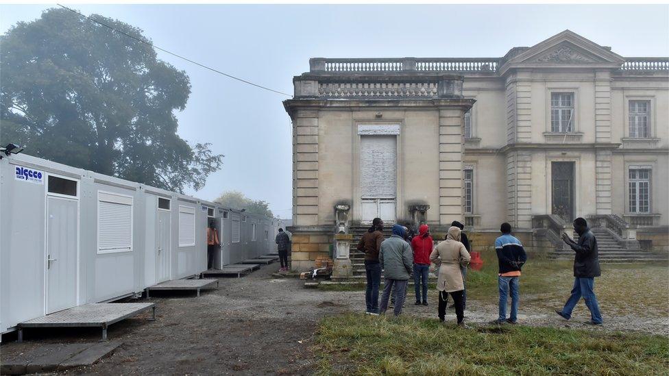 Sudanese migrants, who arrived overnight from the Calais ''Jungle'' camp, stand near temporary accommodations set up in front of the Chateau des Arts in Talence, one of the housing sites for migrants who left Calais, on October 25, 2016