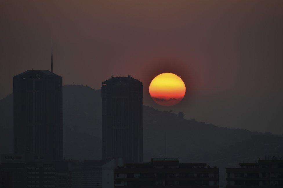 The sun sets in Caracas during a partial power cut on March 25, 2019.