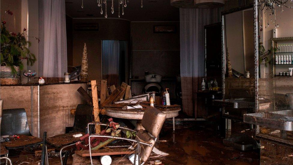 The damaged furniture of a shop is covered with mud, in Mandra, northwest of Athens