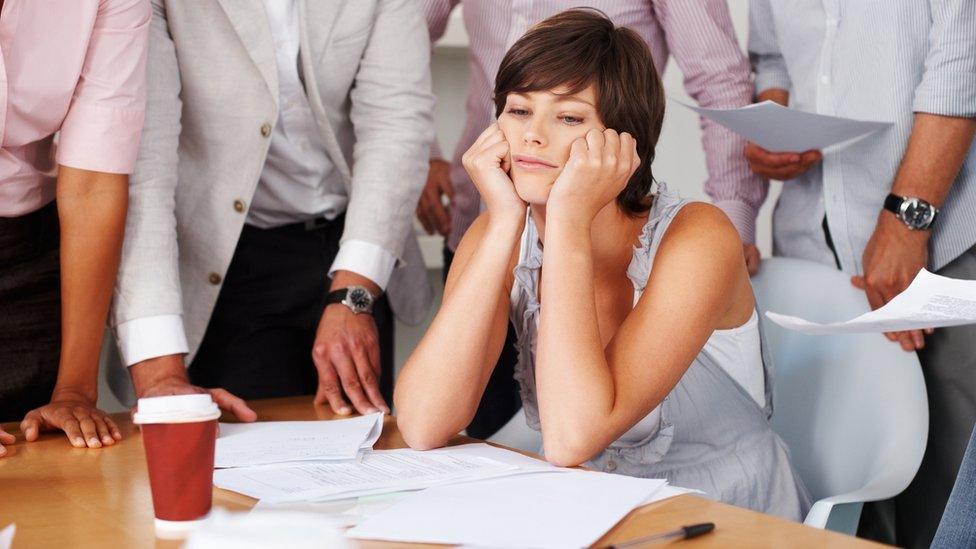 Bored office worker surrounded by people