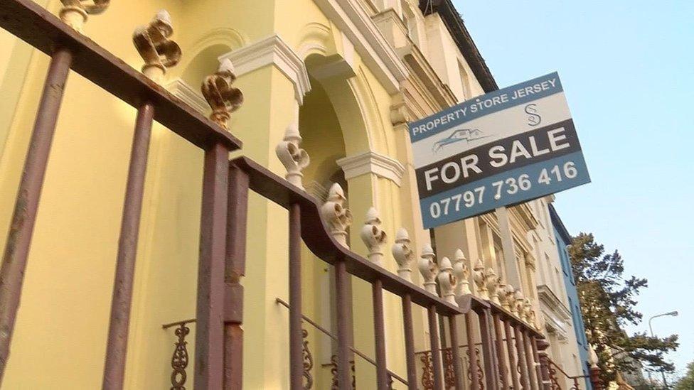 Property for sale sign outside yellow building in Jersey