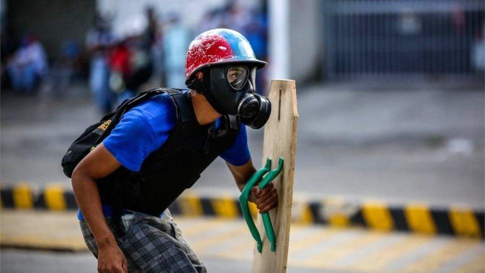 A protestor confronts members of the National Bolivarian Guard during a demonstration against the vote for a Constituent Assembly in Caracas, Venezuela, 30 July 201